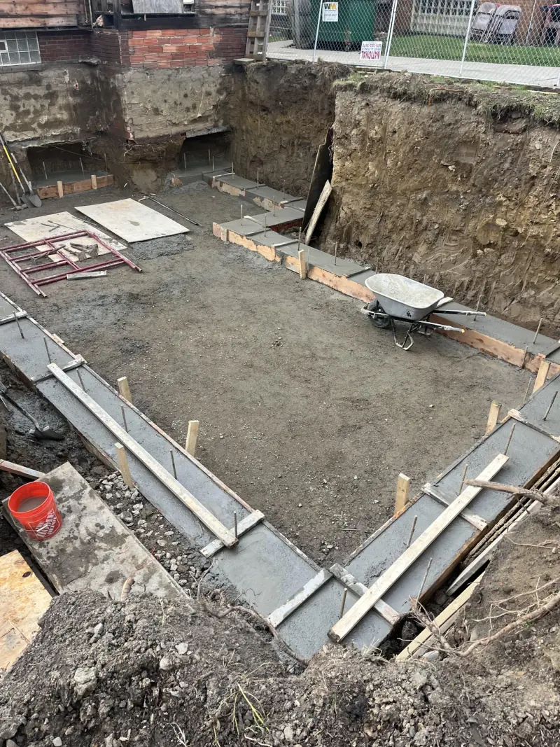 Fresh concrete footings formed inside a deep excavation