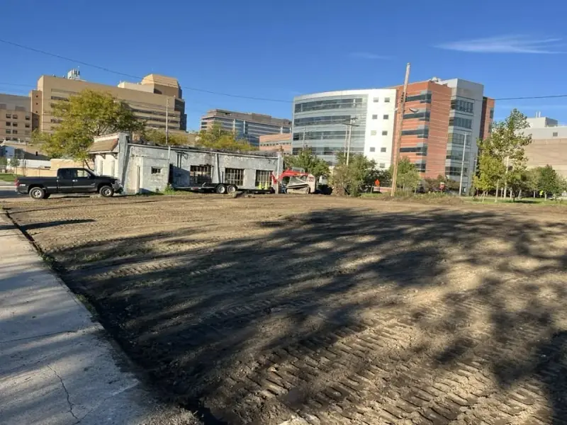Cleared commercial lot with equipment at the far edge