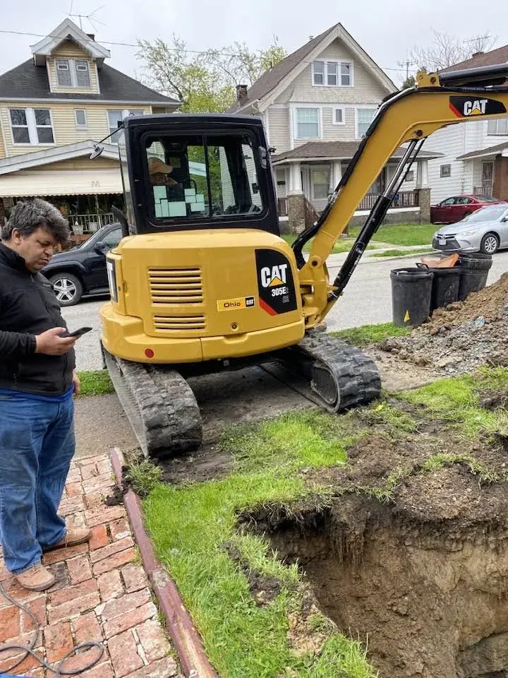 Compact excavator positioned beside a residential excavation