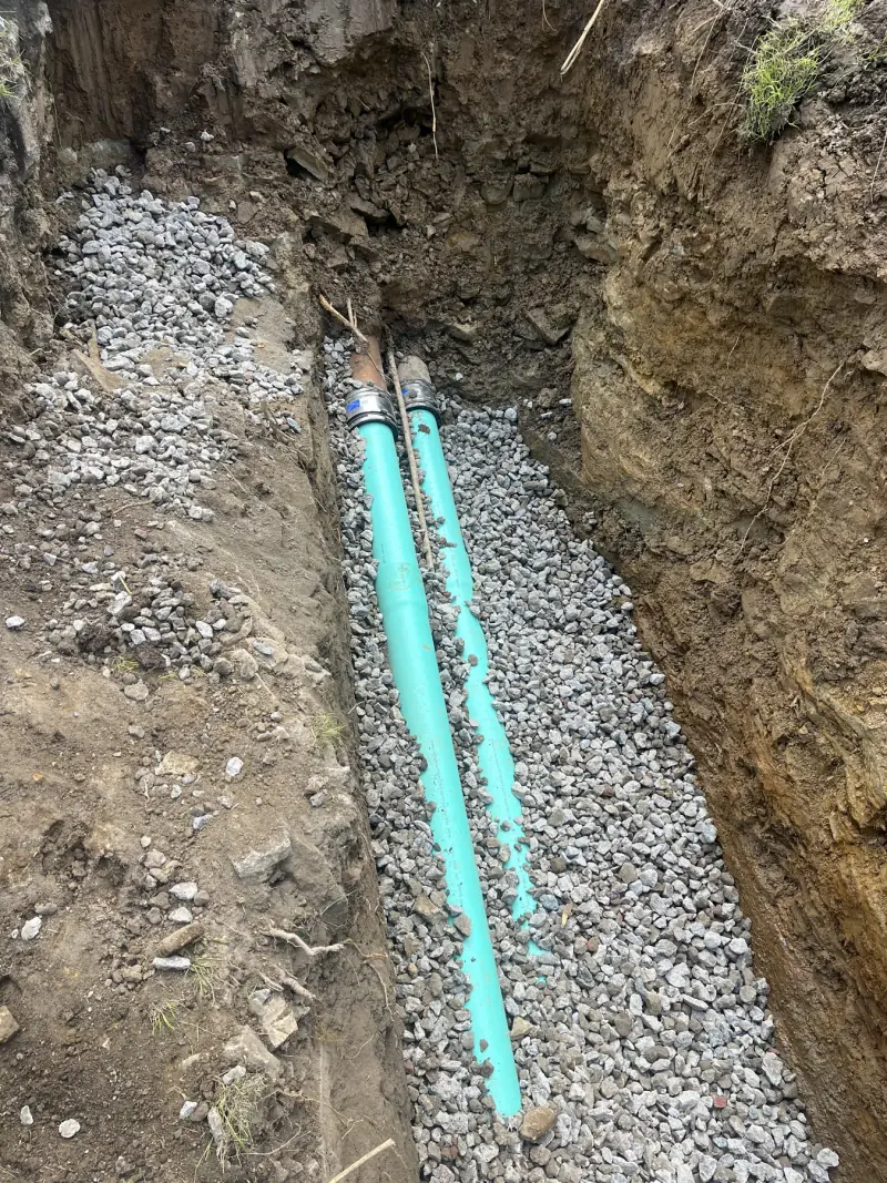 Sanitary and storm line installation beside a building